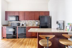 a kitchen with stainless steel appliances and wooden cabinets at Loop 2BR w Gym Doorman nr L Parks CHI-318 in Chicago