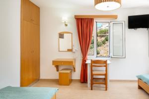 a bedroom with a desk and a window at Vasilis Studios Family House in Kalymnos