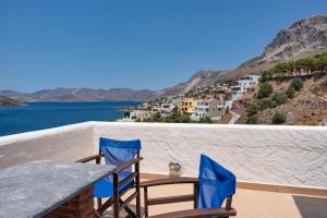 une table et des chaises sur un balcon donnant sur l'océan dans l'établissement Calliope Maille Family House, à Kalymnos