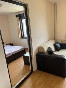 um espelho num quarto com uma cama e um sofá em Хотел-ресторант Шипка,връх Шипка em Prevala