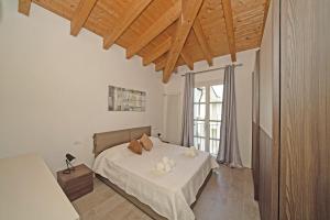 a bedroom with a bed and a large window at Corte Fasanella 47 - Gardagate in Toscolano Maderno