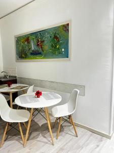 una mesa y sillas en una habitación con una pintura en La Casa di Nonna Emma - Affittacamere, en Palermo