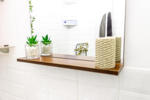 un lavabo con plantas en una estantería de madera en Sky Paradise - M&N Condos, en Bucarest 16 fotos más