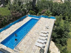 a swimming pool with lounge chairs next to a swimming pool at Olympos Likya Apart Otel in Yenbey