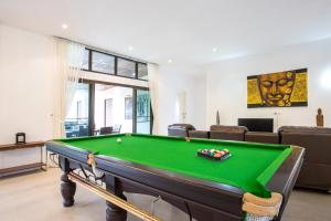 a living room with a pool table in it at Luxury 6BR Pool Villa Oxavia next to NaiHarn Beach in Rawai Beach
