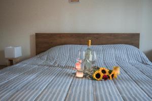 a bed with a bottle and two glasses and a bouquet of flowers at Sea Zen Guesthouse in Rafina