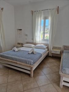 Un dormitorio con una cama grande y una ventana en Harama hotel Schinoussa en Skhoinoussa