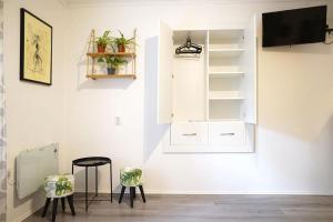 a room with a white wall with shelves and a stool at Apartman Green in Zagreb