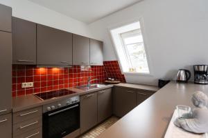 a kitchen with stainless steel appliances and a window at Michels Ferienwohnung Schöne Aussicht in Morsum