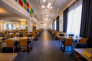 une grande salle avec des tables et des chaises dans un restaurant dans l'établissement Discovery-Borovoe, à Kotarkol