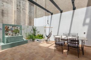 a dining room with a table and chairs and plants at Vilanova Centre in Vilanova i la Geltrú