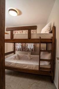 two bunk beds in a room with white sheets at Olympus Mythical Resort in Skotina