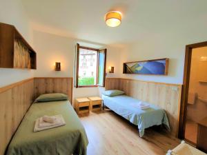 a bedroom with two beds and a window at Casa Maria Angela in Ledro