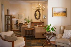 uma sala de estar com um sofá, cadeiras e um espelho em 5 Seasons Guest House em Stellenbosch