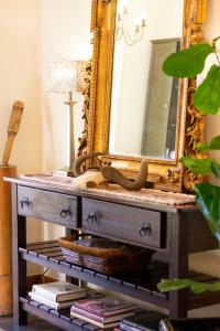um espelho em cima de uma cómoda com livros em 5 Seasons Guest House em Stellenbosch