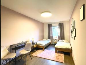 a room with two beds and a desk and chairs at Vienna's Central Gem: Artistic Apartment in the Heart of the City in Vienna