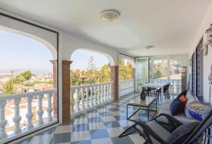 un soggiorno con balcone arredato con tavolo e sedie. di Villa María con Piscina playa y vistas a Caleta de Velez