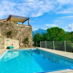 a large blue swimming pool in front of a building at Ca'Luni in Casola in Lunigiana