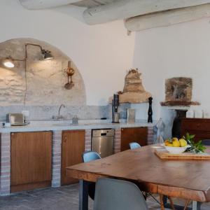 cocina con mesa de madera con sillas y fregadero en Ca'Luni en Casola in Lunigiana
