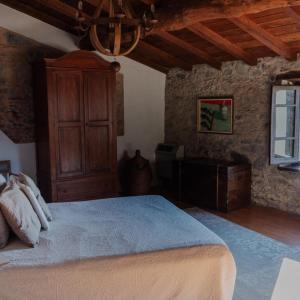 1 dormitorio con 1 cama grande y armario de madera en Ca'Luni, en Casola in Lunigiana