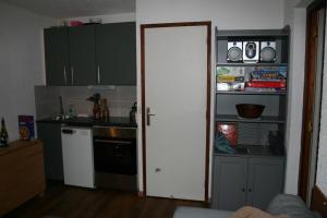 a kitchen with green cabinets and a white door at Ski in and Out 2-Bed Apartment in Meribel in Les Allues