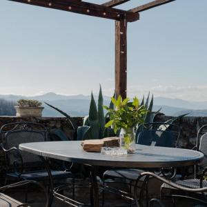 una mesa con sillas y una mesa con un jarrón. en Ca'Luni, en Casola in Lunigiana