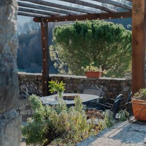 un patio con mesa y sillas y vistas a una colina en Ca'Luni en Casola in Lunigiana