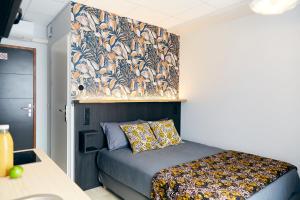 Schlafzimmer mit einem Bett mit Blumentapete an der Wand in der Unterkunft Smart Appart Le Havre 97 in Le Havre
