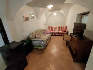 a living room with a couch and a tv at Casa Maria Angela in Ledro