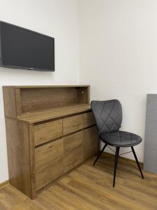 a chair and a television on a wall at Ubytovanie HAMAR 17 in Banská Bystrica