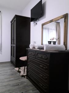 a dresser with a mirror on top of it at Pensiunea Cosalina Grande in Slănic-Moldova