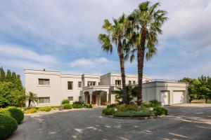 a large white house with palm trees in the driveway at Bello Blu Estate Luxury Mediterranean Villa in Asgourou