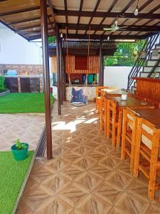 un patio con mesa y sillas bajo una pérgola en CASA MIA INN, en Dauis