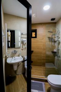 a bathroom with a sink and a shower and a toilet at Hotel Evergreen in Borjomi