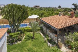 a garden with a swimming pool and a house at Elli's apartment 2 in Antimácheia