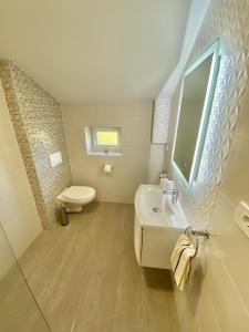 a bathroom with a sink and a toilet and a mirror at Theros in Bibinje +42 photos