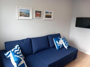 a blue couch in a living room with pictures on the wall at Blue Chill Apartment in Liepāja