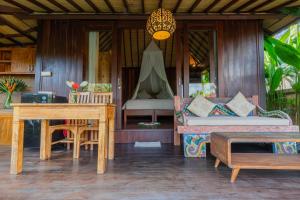 un tavolo da pranzo e un divano su un portico di una casa di NILUH Private Villas ad Ubud