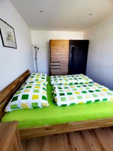 a bedroom with a large bed with green sheets at Zentrumsnahe Privatunterkunft Freistadt in Freistadt