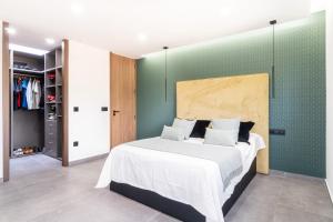 Un dormitorio con una cama grande y una pared verde en Altafulla Piscina 4BD Beach BBQ Wifi Portaventura en La Riera