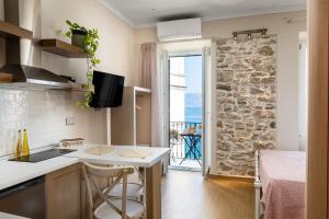 a kitchen with a sink and a counter top at Fotiadis Family Luxury Suites by Konnect in Corfu Town