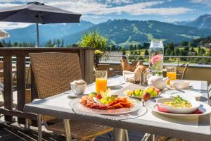 un tavolo con un piatto di cibo su un balcone di Hotel Berghof a Ramsau am Dachstein
