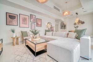 ein Wohnzimmer mit einem weißen Sofa und einem Tisch in der Unterkunft Spectacular 3BR Townhouse with Assistant Room and Private Pool at DAMAC Hills 2 Dubailand by Deluxe Holiday Homes in Dubai