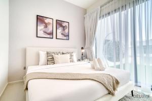 ein weißes Schlafzimmer mit einem großen Bett und einem Fenster in der Unterkunft Spectacular 3BR Townhouse with Assistant Room and Private Pool at DAMAC Hills 2 Dubailand by Deluxe Holiday Homes in Dubai