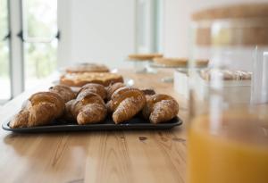 una bandeja de donuts en una mesa con un vaso de zumo de naranja en Villa Angeline, 
