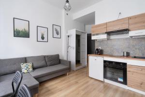 a living room with a couch and a kitchen at RentPlanet - Studio Żeromskiego in Wrocław