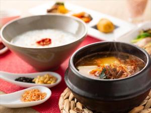 a bowl of soup and bowls of food on a table at JR Kyushu Hotel Blossom Fukuoka in Fukuoka