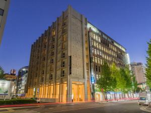 a large building on a city street at night at JR Kyushu Hotel Blossom Fukuoka in Fukuoka