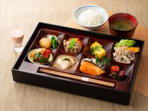 JR Kyushu Hotel Blossom Fukuoka في فوكوكا: صينية طعام مع السوشي والأرز على طاولة
