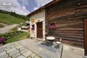 - un bâtiment avec une table et des chaises à l'extérieur dans l'établissement Mountain Chalet Scoiattolo, à Livigno